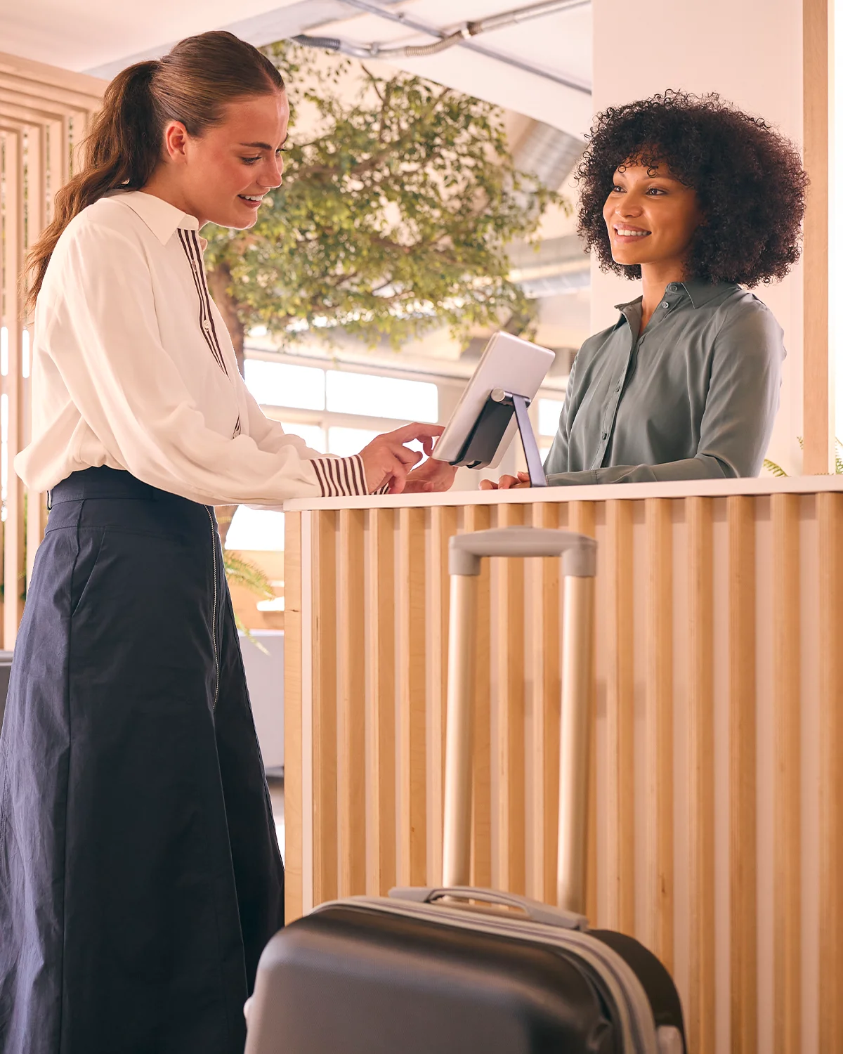 Hóspede concluindo o check-in em um hotel, com recepcionista